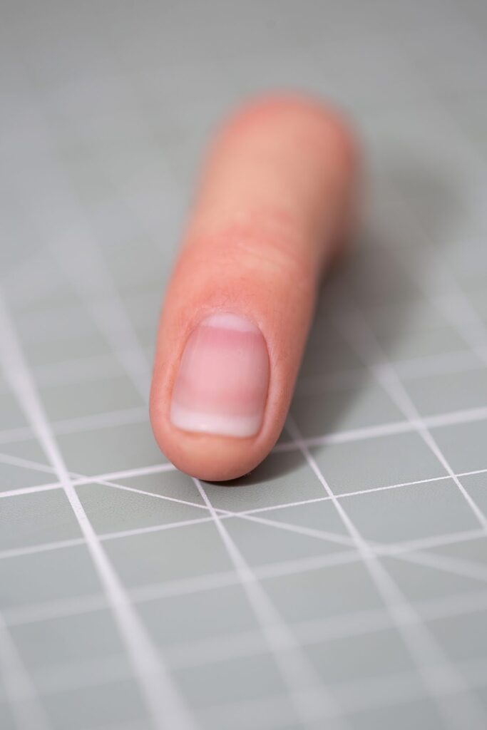 Silikon-Fingerprothese auf Schneidematte – APO-Silikon